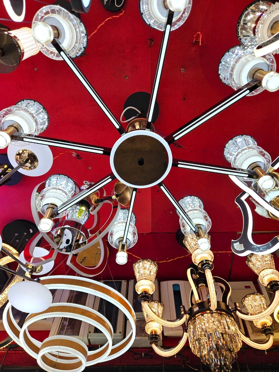Lit chandeliers hanging from the red velvet ceiling inside Kigali Source Company